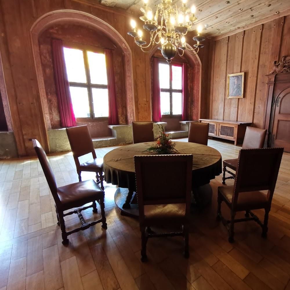 A wood-paneled room with a round table and chairs.
